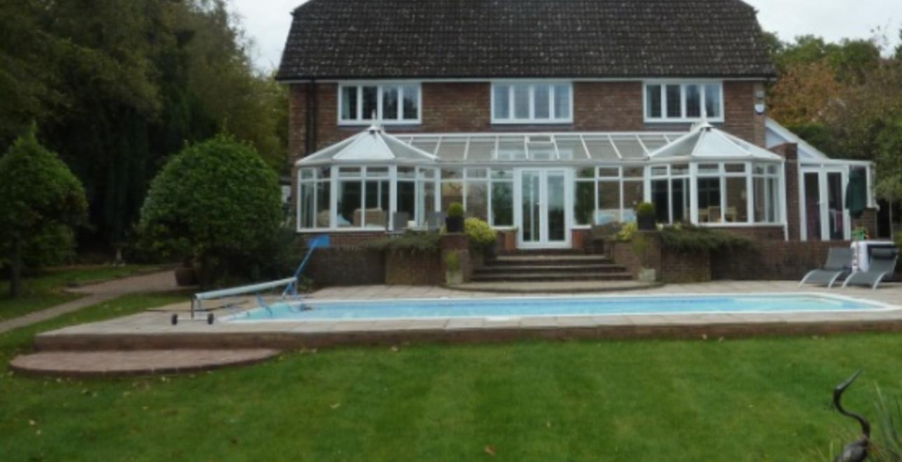 Outdoor swimming pool beside a home